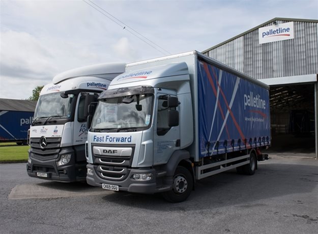 Two Palletline delivery lorries parked outside a warehouse, with prominent ‘Fast Forward’ and ‘Network Freight Distribution’ branding on the vehicles and building.